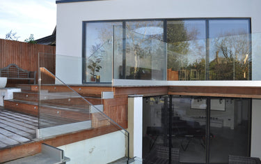 Frameless glass balustrade on a garden terrace at a modern home, installed by CreoGlass