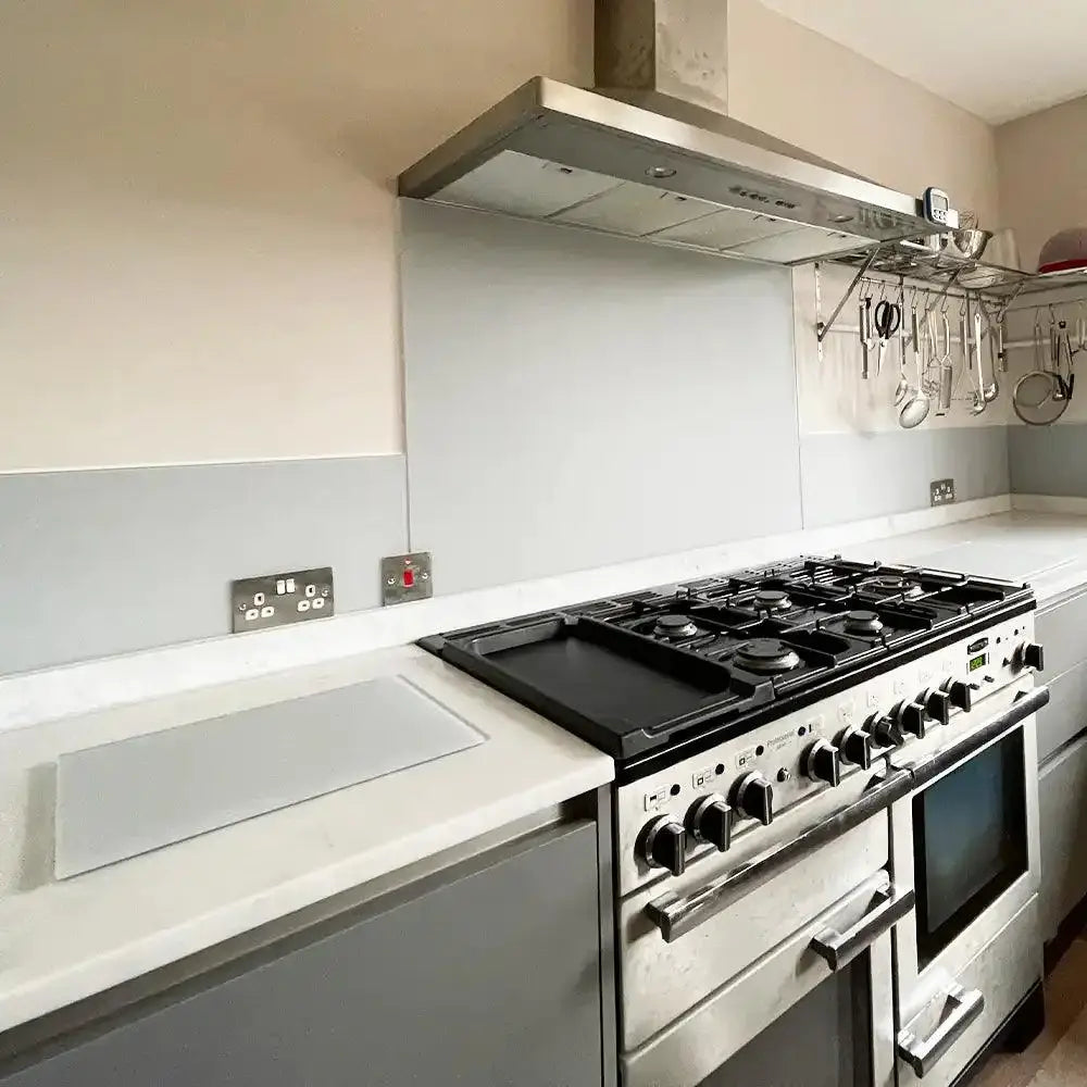 Sleek grey glass kitchen splashback behind stainless steel range cooker and hood
