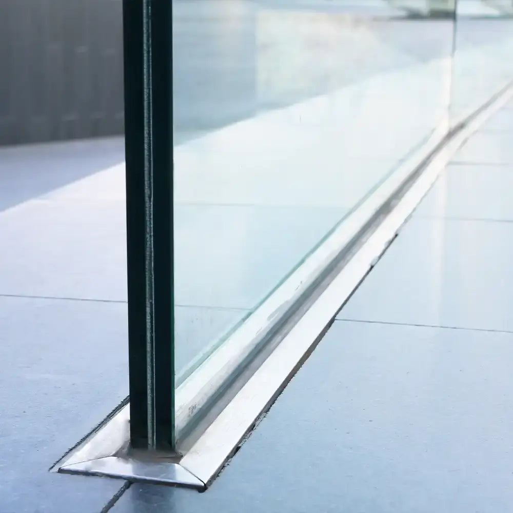 Modern glass balustrade with sleek metal base, ideal for luxury residential and commercial spaces.