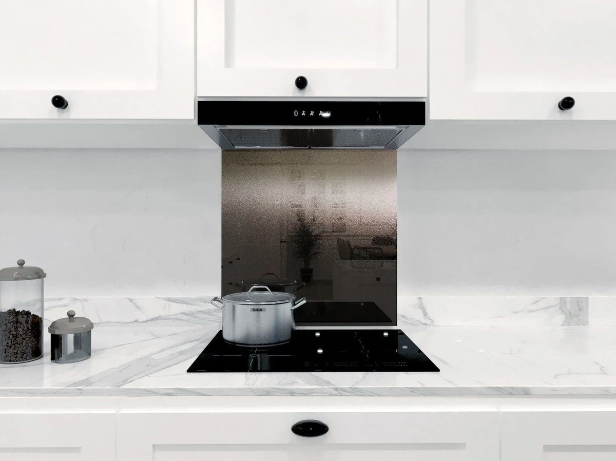 Modern kitchen with frosted glass splashback behind induction hob and extractor hood