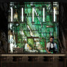 Bar with a decorative LED wall displaying bottles, featuring a bartender.