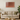 Modern living room with beige sofa, round wooden coffee table, green plant, and copper glitter wall art