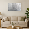 Modern living room with beige sofa, green pillows, wooden coffee table, silver glitter wall art