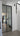 Modern interior with black framed double hinged glass door leading to kitchen area and white staircase