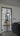 Modern double hinged glass door with black frame opening between living areas with sofas