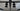 Close-up of black double hinged door handles on glass doors with light patterned floor background