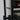 Close-up of modern black metal door handle on glass double hinged door with frame
