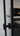 Close-up of modern black metal door handle on glass double hinged door with frame