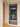 Modern black framed glass hinged door installed indoors, next to wooden door and beige walls