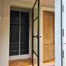 Modern interior with a black metal framed glass hinged door and wooden floor