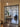 Black metal frame double door with two side panels opening to a modern living room with wooden floors