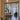 Modern black metal double door with side panels opening to a bright living room with beige sofas and wooden floor