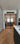 Modern interior with black framed double hinged glass doors between kitchen and living room with wooden herringbone floor