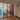 Modern interior with black metal framed glass double doors separating dining and living rooms with wood flooring