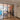 Black framed double glass doors with two side panels separating modern dining area and living space