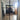 Double hinged black metal frame glass doors opening to a modern kitchen with chevron wooden floor