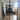 Double hinged black metal frame glass doors opening to a modern kitchen with chevron wooden floor