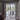 Modern black metal frame double hinged glass door opening to a bright dining area with outdoor garden view
