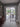 Modern black metal frame double hinged glass door opening to a bright dining area with outdoor garden view