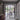 Modern double hinged black frame glass doors opening to a bright dining area with wooden table and garden view