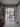 Modern double hinged black frame glass doors opening to a bright dining area with wooden table and garden view