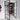 Double hinged black metal frame glass doors open to a room with wooden sideboard and large mirror