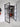 Double hinged black metal frame glass doors open to a room with wooden sideboard and large mirror