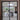 Modern black metal framed glass double hinged door opening to dining area with wooden table and backyard