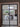 Modern black metal framed glass double hinged door opening to dining area with wooden table and backyard