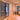 Modern interior with double hinged black metal frame glass doors and light wood herringbone floor