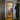 Black framed glass hinged door in hallway leading to modern kitchen with wooden floor
