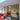 Modern interior with exposed brick wall, black framed glass door, orange sofa, and chess table