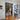 Modern interior with black double hinged glass doors on wooden parquet floor, view into home office and living space