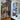 Black double hinged glass door with frame leading to a living space, adjacent to refrigerator with photos and notes