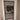 Modern hinged glass door with black metal frame and white trim in beige interior