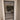 Modern hinged glass door with black metal frame and white trim in beige interior