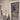 Modern interior hallway with black framed glass hinged doors and gray upholstered bench