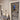 Modern interior hallway with black framed glass hinged doors and gray upholstered bench