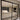 Modern double hinged black metal frame glass door separating tiled hallway and living room