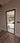 Modern black framed hinged glass door with metal handle in a neutral indoor setting