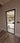 Modern black framed hinged glass door with metal handle in a neutral indoor setting