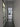Modern hallway with frosted glass door and black-framed glass hinged door leading to living room