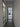 Modern hallway with frosted glass door and black-framed glass hinged door leading to living room