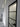 Modern interior hallway with a black-framed frosted glass hinged door and white walls