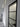 Modern interior hallway with a black-framed frosted glass hinged door and white walls