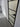 Modern hinged interior door with black metal frame and frosted glass panels in a minimalist hallway