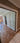Interior view of a modern home with a glass double hinged door and wooden herringbone floor