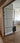 Double hinged glass door with metal frame in modern interior with wooden herringbone floor
