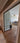 Double hinged glass door with metal frame in a modern living room with wooden herringbone floor