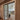 Double hinged glass doors with metal frame separating hallway with patterned rug from modern living room